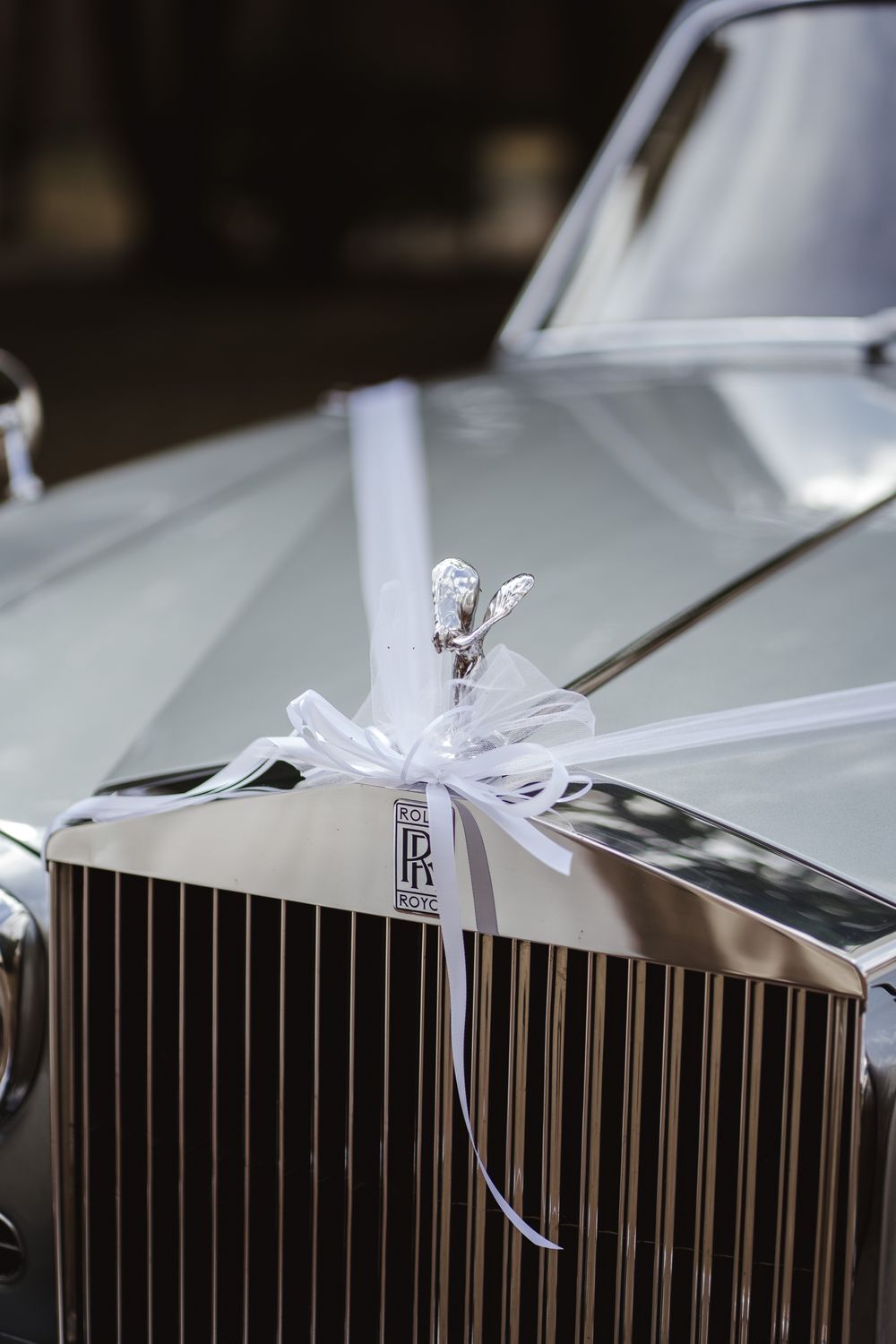 Kühlerfigur des Rolls-Royce mit weißer Schleife