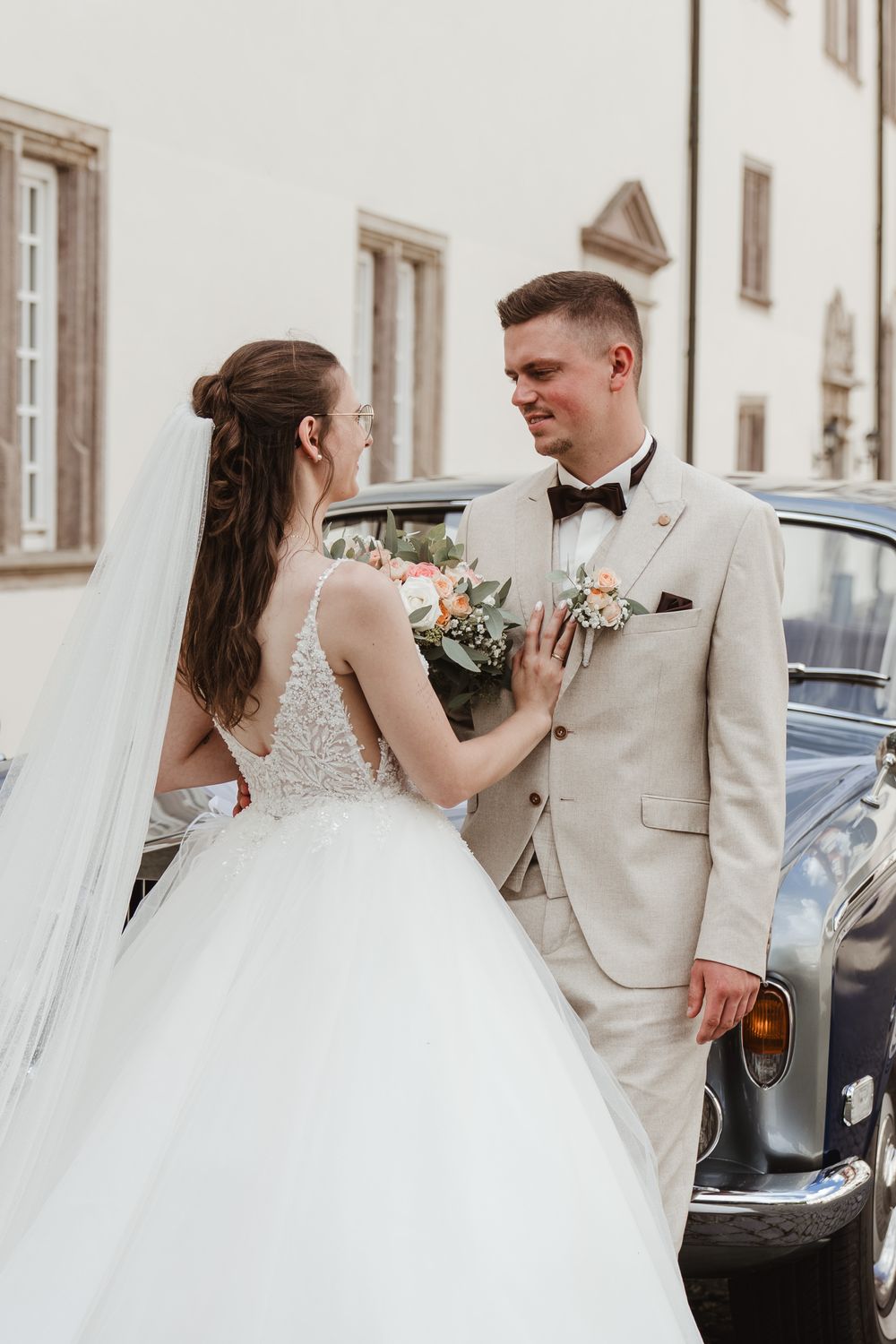 Brautpaar am Rolls-Royce vor dem Schloss
