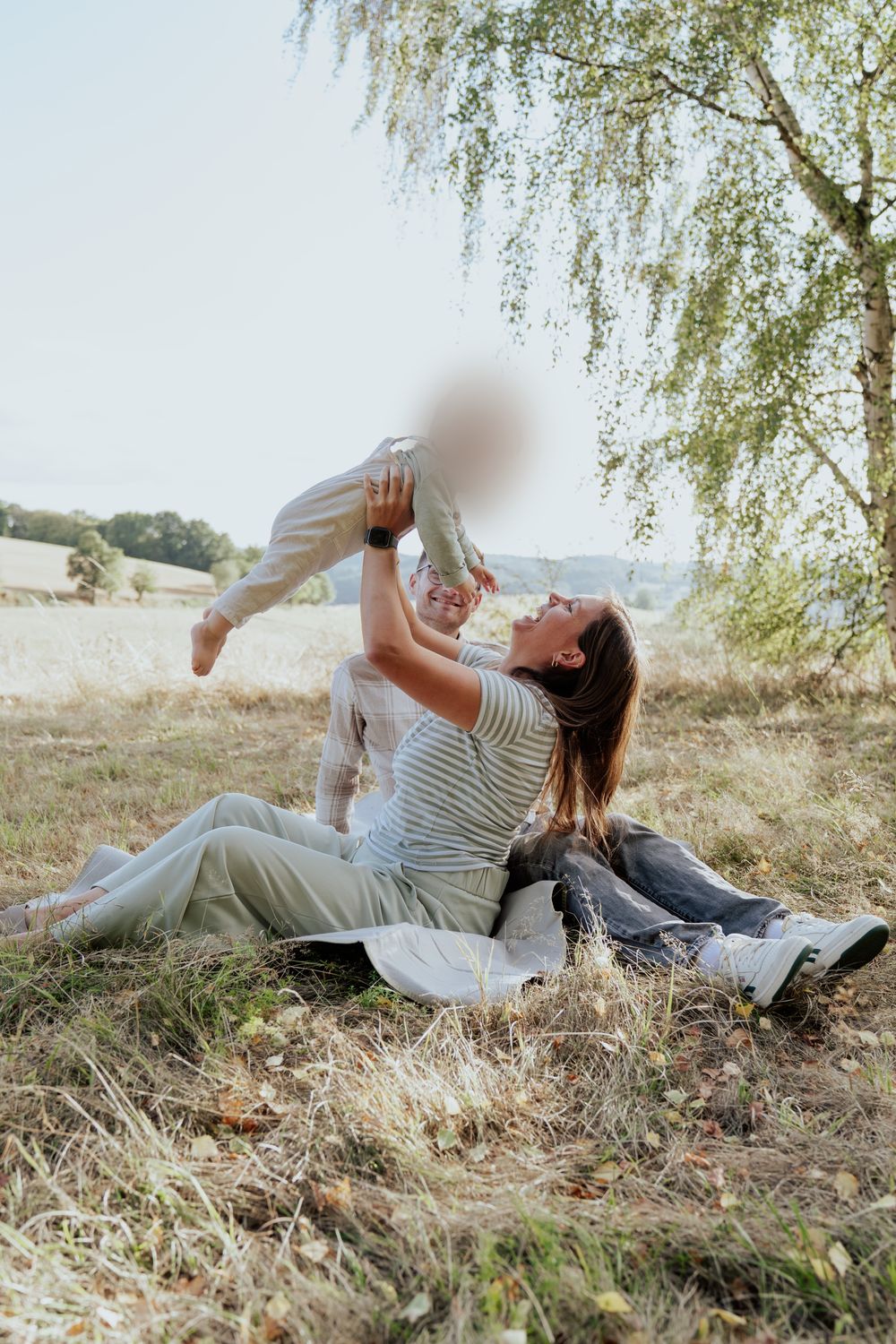 Mama hebt ihr Baby in die Luft